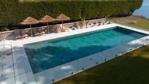 una vista aérea de una piscina con sillas y sombrillas en Malates Slow Boutique Hotel, en Foz