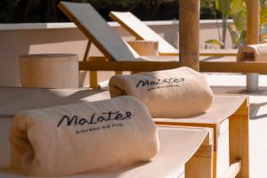 twee opvouwbare handdoeken op een tafel met stoelen bij Malates Slow Boutique Hotel in Foz