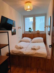 sypialnia z dużym łóżkiem z dwoma ręcznikami w obiekcie Apartament Zakątek Kudowa Przytulny w Kudowie Zdroju