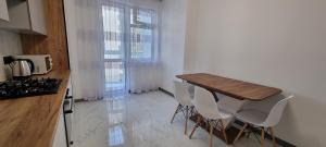 uma cozinha com uma mesa de madeira e cadeiras brancas em Квартира біля озера ЖК Панорама em Ternopilʼ