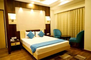 a hotel room with a bed and two chairs at Hotel Avenue Plaza, Serampore - N S Avenue 