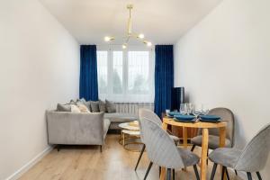 a living room with a couch and a table with chairs at Katowicka Comfy Apartments next to Spodek by Renters in Katowice