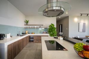 a kitchen with a large island with a bowl of fruit at The Sense Apartment - Modern, Near My An Beach in Da Nang