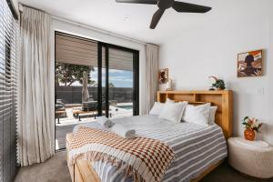 a bedroom with a bed and a large window at Luxury Escape with ocean views. in Papamoa +21 photos