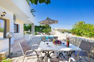 a patio with a table and chairs and a pool at Villa Marilia in Astérion