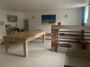 a room with a table and a brick fireplace at Aux petits bois in Morbecque
