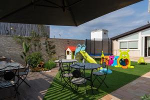 a backyard with a table and chairs and a playground at Villa Dario in Castellana Grotte