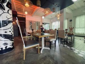 - une salle à manger avec une table et des chaises dans l'établissement The ApplePeach House, à Legazpi