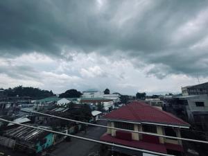 a view of a city with buildings and a cloudy sky at The ApplePeach House in Legazpi