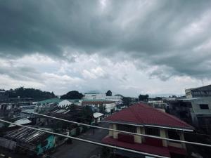 une vue sur une ville avec des bâtiments et un ciel nuageux dans l'établissement The ApplePeach House, à Legazpi