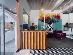 a lobby with a counter and people sitting in a room at The ApplePeach House in Legazpi