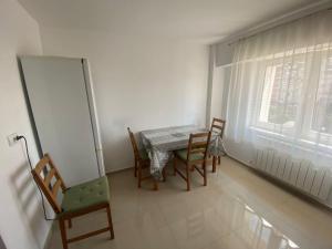a dining room with a table and chairs and a window at Apartament Central Suceava in Suceava