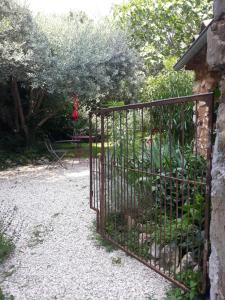um portão de ferro num jardim com um baloiço em La maison du jardin em Rustrel