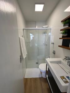 y baño con ducha, aseo y lavamanos. en Studio 104 no Kobrasol à 7km de Floripa en São José