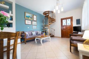 a living room with a couch and a spiral staircase at Villa Marilia in Astérion