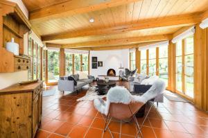 sala de estar con techos de madera, mesa y sillas en Chalet Steinberg en Leogang