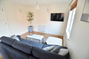 a living room with a blue couch and a table at Luxury 2 BR Fully Furnished Flat in Crawley - 2 FREE Parking Spaces in Crawley