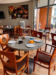 comedor con mesa, sillas y mesas en Residhome Paris-Guyancourt, en Guyancourt