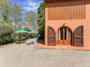 un edificio con un patio con mesas y sombrillas en Belvilla by OYO Casanova D pendance, en Querce