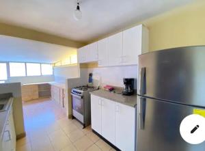 里奧班巴的住宿－CASA IDEAL，厨房配有不锈钢冰箱和白色橱柜