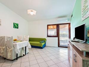 een woonkamer met een bank en een tafel met een televisie bij Beautiful Apartment in Jasenice near Sea in Jasenice