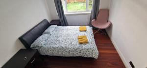 a small bedroom with a bed and a chair at Ritzs place in Northolt