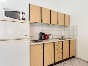 - une cuisine avec des placards en bois et un réfrigérateur blanc dans l'établissement Beautiful Apartment in Jasenice near Sea, à Jasenice