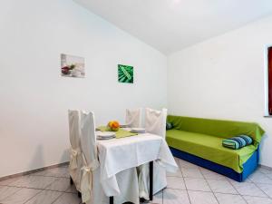 une salle à manger avec un canapé vert et une table dans l'établissement Beautiful Apartment in Jasenice near Sea, à Jasenice