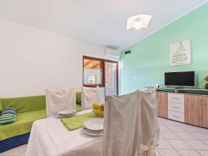 - un salon avec une table et un canapé vert dans l'établissement Beautiful Apartment in Jasenice near Sea, à Jasenice