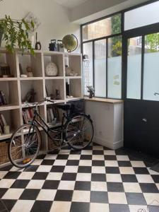 uma bicicleta estacionada numa sala com um piso xadrez em Maison piscine centre historique de Romainville em Romainville