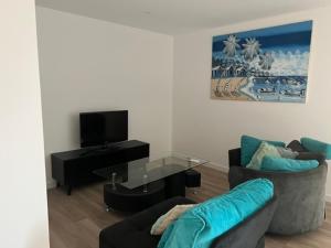 a living room with a couch and a tv at Le Vox - appartement de centre-ville in Montélimar