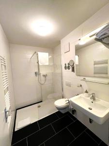 a bathroom with a shower toilet and a sink at Schubart Apartments in Bietigheim-Bissingen