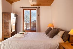 uma grande cama branca num quarto com uma janela em Chalet du Golf 618 - Happy Rentals em Chamonix-Mont-Blanc