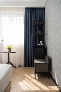een kamer met een stoel en een tafel met een raam bij Mitico Hotel & Natural Spa in Bologna