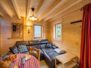 a living room with a leather couch in a log cabin at Nordic Lodge in Peisey-Nancroix