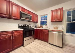 a kitchen with wooden cabinets and a black appliance at Beautiful Victorian house, Great Views, free parking in Boston
