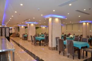賈贊的住宿－فندق جولدن أرمادا جيزان Golden Armada Hotel，一间配备有蓝色桌椅的用餐室