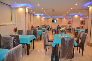 un salón de banquetes con mesas y sillas azules en جولدن أرمادا جيزان Golden Armada Hotel, en Jazan