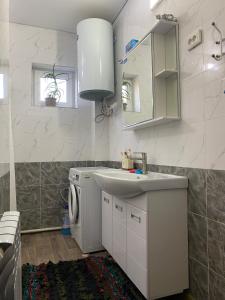 a bathroom with a sink and a washing machine at Handicraft house in Karakol