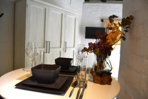 a table with glasses and a vase of flowers on it at Private Studio with Kitchenette in Cape Town