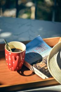 dos libros y una taza de café en una mesa en Village de gites Le Frigoulet, en Balazuc
