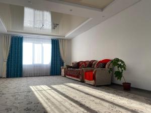 a living room with a couch and a window at Handicraft house in Karakol