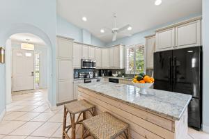 a kitchen with a large island with a bowl of fruit on it at Neapolitan Vacation Rental in Naples