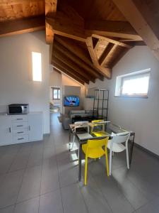 Crevoladossola的住宿－La Casetta del Ponte，一间设有玻璃桌和黄色椅子的用餐室