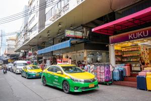 two yellow and green cars parked in front of a store at Budacco The Living Place in Bangkok