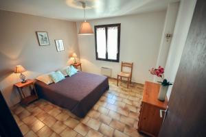 1 dormitorio con 1 cama, 1 mesa y 1 silla en Village de gites Le Frigoulet, en Balazuc