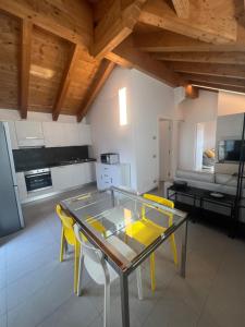 Crevoladossola的住宿－La Casetta del Ponte，一间设有玻璃桌和黄色椅子的用餐室