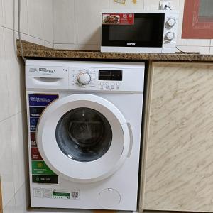 a washing machine with a microwave on top of it at Al Basam Center in Dubai