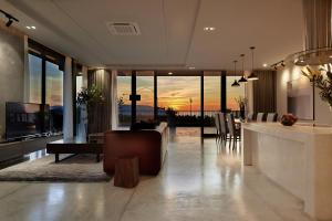 岘港The Sense Apartment - Modern, Near My An Beach的客厅设有酒吧,享有日落美景