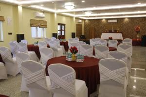 a room with white chairs and tables and a room with tables and white chairs at JHARNA RESORT in Purulia +54 photos